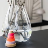 Kleiner Holz-Scheibenturm von Grimm's in Neonpink vor Vase