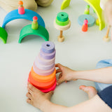 Kinderhände mit großem Scheibenturm aus Naturholz von Grimm's in Neonpink