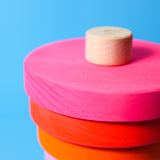 Nahaufnahme von großem Scheibenturm aus Naturholz von Grimm's in Neonpink