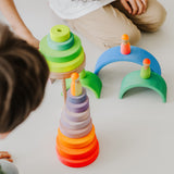 Kinder am Spielen mit großem Scheibenturm aus Naturholz von Grimm's in Neonpink