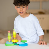 Kind mit Großer Holz-Scheibenturm von Grimms in Neongrün