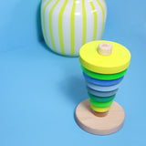 Großer Holz-Scheibenturm von Grimms in Neongrün vor hellblauem Hintergrund