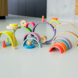 Mehrere Regenbogen Motorikspiele von Grimm's aus Holz in Neonfarben miteinander verbaut