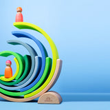 Aufeinander gebaute Teile von Regenbogen Motorikspiel von Grimm's aus Holz in Neongrün