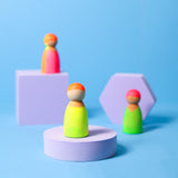 Mix aus 3 Grimm's Neonfreunden aus Naturholz vor hellblauem Hintergrund