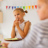 Geburtstagsfeier mit Grimm's Wimpelkette aus Holz in Regenbogenfarben im Hintergrund