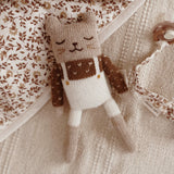 Main-Sauvage-Kaetzchen-aus-Alpaka-Wolle-weisse-Latzhose-auf-Bettdecke