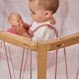 Kind am Spielen in Babybett KIMI von Charlie Crane in Bois de Rose Farbton