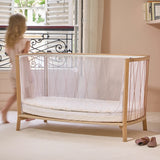 Geöffnetes Babybett KIMI von Charlie Crane in Bois de Rose Farbton mit Kind
