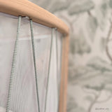 Nahaufnahme des Rahmens von Babybett KIMI von Charlie Crane mit moosgrünen Schnüren