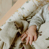 Nahaufnahme von Kinderhand in Charlie Crane Babywippe LEVO im Mimosa Design