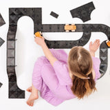 Mädchen spielt mit Connetix Magnetbausteine Roads Creative Pack mit 48 Teilen in Verpackung