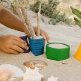 Kind am Spielen mit bunten Holzgefäßen von Grapat