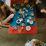 Kinder spielen an Tisch mit Handbemalten Holztellern Dishes von Grapat