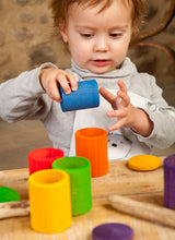 Kind am Spielen mit Grapat Holzbechern mit Deckel