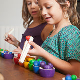 Kinder beim Spielen mit Grapat Schälchen und Eicheln in Regenbogenfarben