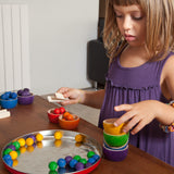 Kind beim Spielen mit Grapat Schälchen und Holzmurmeln
