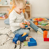 Kind am Spielen mit Nachzieh-Lastwagen von Grimm's