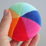 Regenbogenball von Grimm's in Hand gehalten