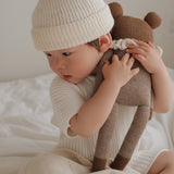 Kind kuschelt mit Großerm Teddy mit beigem Strampler von Main Sauvage