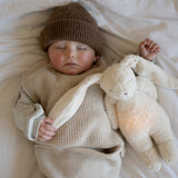 Baby mit Moonie Einschlafhilfe und Kuscheltier-Hase im Farbton Organic Polarweiss