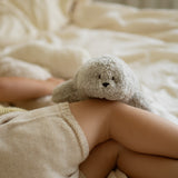 Moonie Einschlafhilfe Robbe im Farbton Organic Grau auf Kind liegend