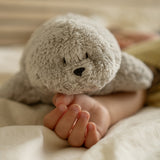 Moonie Einschlafhilfe Robbe im Farbton Organic Grau auf Kinderhand