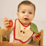 Kind an Esstisch mit Apfel-Lätzchen "Pepa the Apple" von Oli&Carol