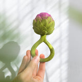 Hand hält Oli & Carol Artischocken Beißring und Rassel