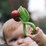 Kind hält Kirschen-Beißring und Rassel von Oli & Carol