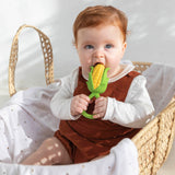 Kind in Moseskorb mit Oli & Carol Maiskolben Beißring und Rassel