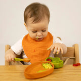 Kind am Essen mit Holzeller und Löffel "Cathy the Carrot" in Karottenform von Oli&Carol