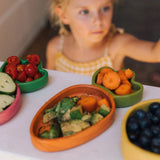 Kind vor mit Essen befülltem Holzeller "Cathy the Carrot" in Karottenform von Oli&Carol