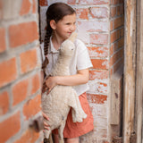 Kind vor Ziegelwand stehend mit großer Gans im Farbton Leinen von Senger Naturwelt