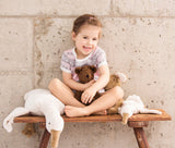 Mädchen auf Holzbank mit Kuscheltieren von Senger Naturwelt