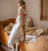 Kind steht in Bett mit XXL Gans Senger Naturwelt