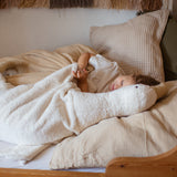 Kind liegt im Betten neben XXL Gans von Senger Naturwelt