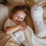 Kind liegt in Bett neben XXL Gans von Senger Naturwelt