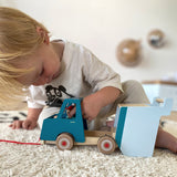 Kind am Spielen mit Nachzieh Fahrtzeug Kipplaster von small foot