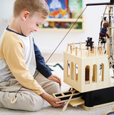 Kind mit Piratenschiff aus Holz von small foot mit Zubehör