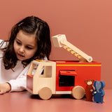 Mädchen spielt mit Trixie Feuerwehrauto aus Holz mit Tieren