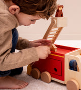 Kind spielt mit Trixie Feuerwehrauto aus Holz mit Tieren
