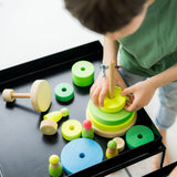 Kind am Spielen mit großem Holz-Scheibenturm von Grimms in Neongrün