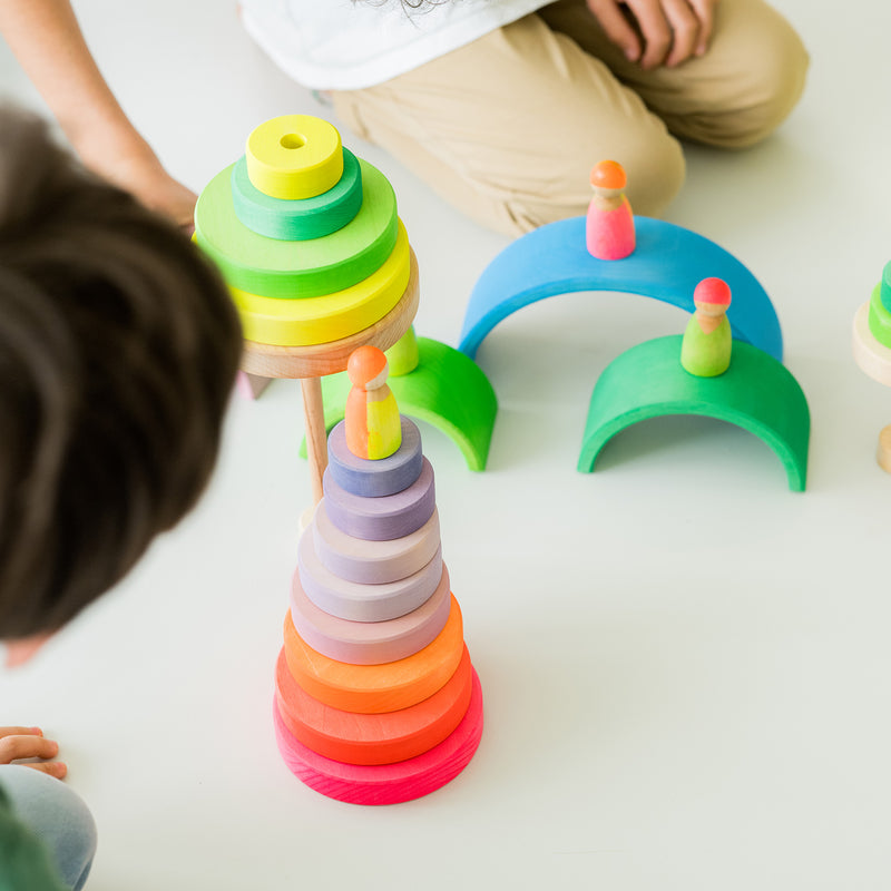 Kinder am Spielen mit Grimm's Holzspielzeug in Neonfarben