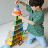 Junge am Spielen mit Holzspielzeug in Neonfarben von Grimm's