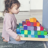 Kind mit Großer Grimm's Stufenpyramide mit 100 Holzbausteinen in Regenbogenfarben