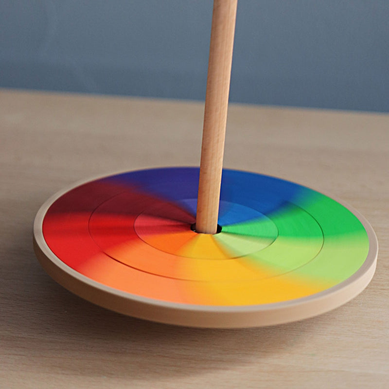 Handkreisel "Göthe" von Grimm's in Regenbogenfarben auf Tischplatte