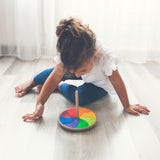 Kind am Spielen mit Handkreisel "Göthe" von Grimm's in Regenbogenfarben