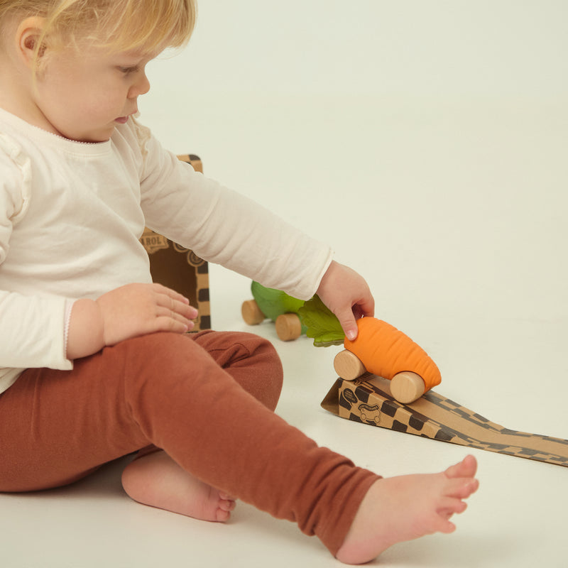 Kind am Spielen mit Karotten Baby-Spielzeugauto Cathy the Carrot von Oli & Carol