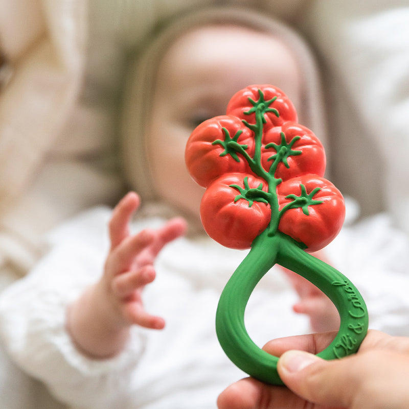 Tomanten-Beißring aus Naturkautschuk von Oli & Carol wird Baby gereicht